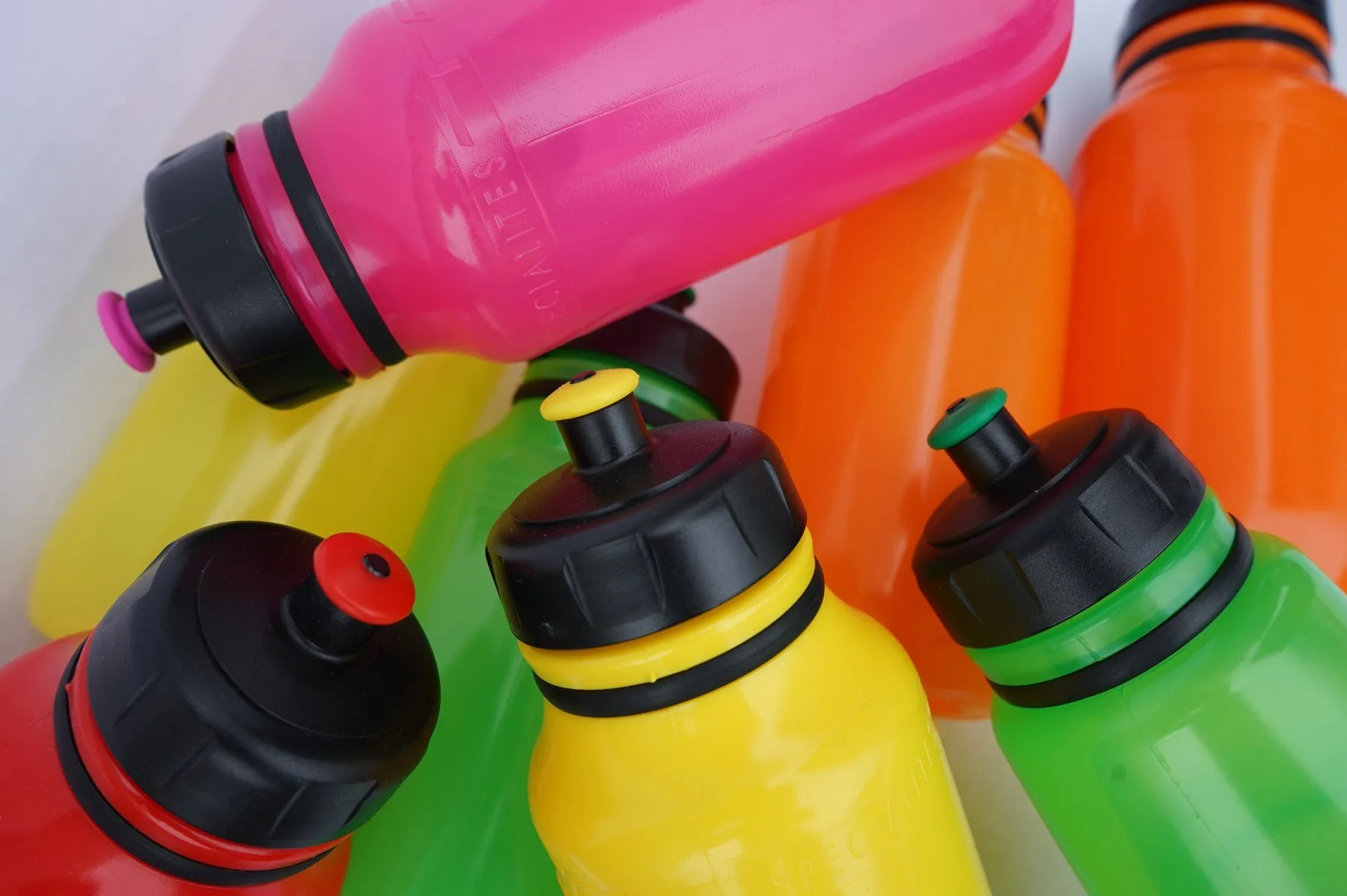 Bidons de vélo Spécialités T.A. en rose, orange, jaune, vert et rouge fluo